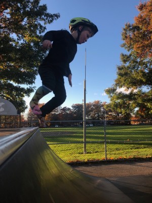 Elijah jumping into the halfpipe to slide down on his socks