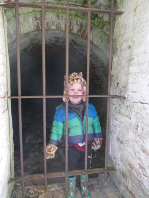 Lijah behind a rusty iron jail door