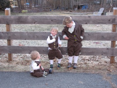 the boys clowning around in front of the fence in their Easter suits