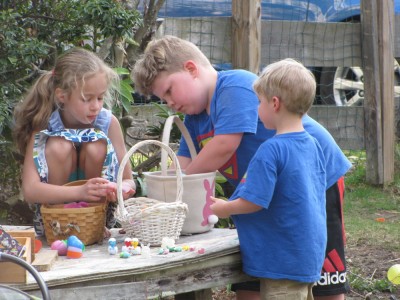 Harvey, Zion, and Havana sorting eggs on the stage