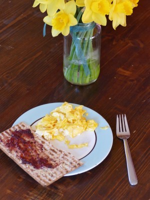 breakfast plate: scrambled eggs and jam on matzo, near daffodils