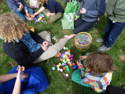 kids sitting on the lawn trading easter egg treats