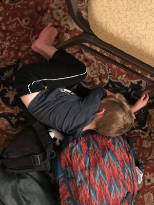 Lijah sleeping on the floor among bags