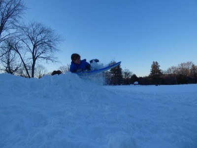 Elijah going off a jump on a sled, and starting to crash