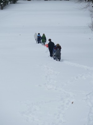 kids walking across a wide snowy field
