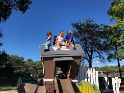 Zion, Elijah, and friends atop a playhouse roof at Friendship Park