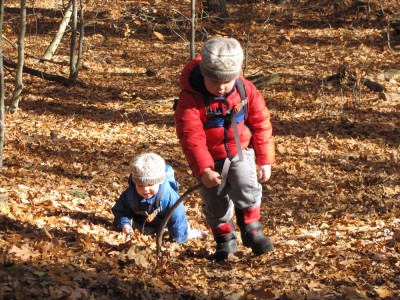 Harvey and Zion coming up a hill on brightly-lit fall leaves