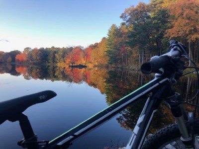 my bike in front of a still pond and fall foliage