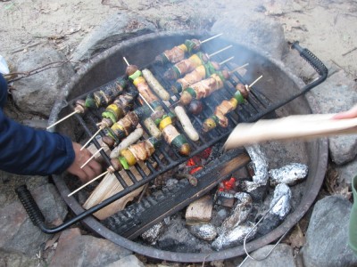 shishkabobs and sausages on the campfire grill