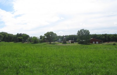 a view of Great Brook Farm beyond the fields