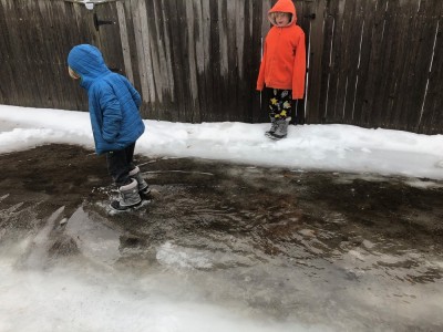 Zion and Elijah walking in a big puddle
