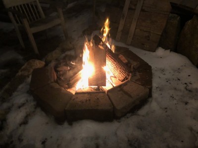 a fire in the fire pit surrounded by snow