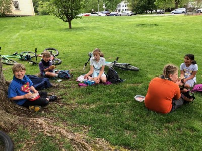 the boys and friends eating a picnic on the grass in Lexington Center
