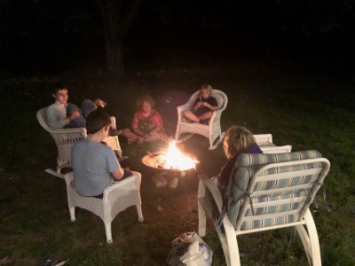 the boys and friends sitting around a fire