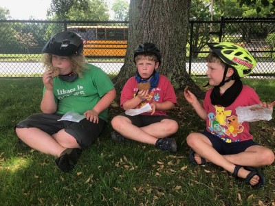 the boys eating cookies under a tree