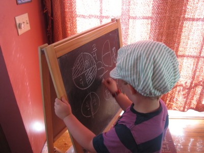 Harvey writing a fraction on the blackboard