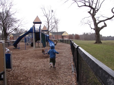 Harvey running towards the play-structure on the snow-free playground