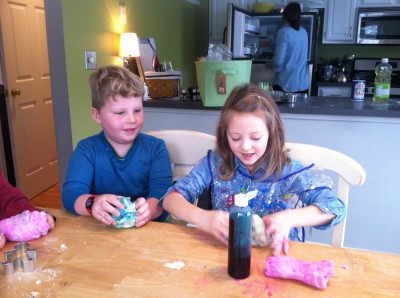 Harvey and Taya coloring their playdough at Taya's kitchen table