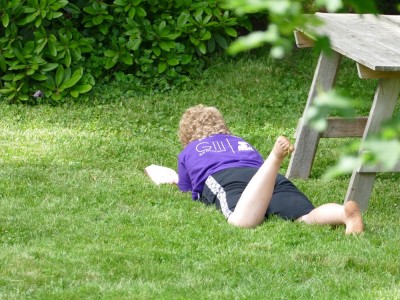 Harvey lying in the grass reading a book