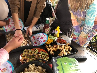 food on a picnic table with hands reaching for it