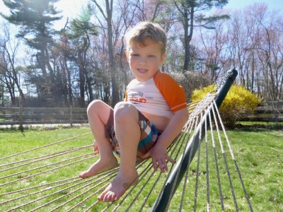 Lijah sitting up on the end of the hammock