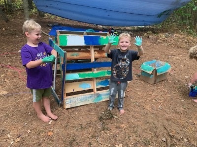 Zion and Lijah painting some pallets and their hands green
