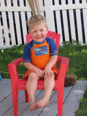 Lijah smiling in a little red chair