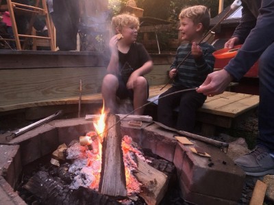 Zion and Elijah having fun eating smores by the fire