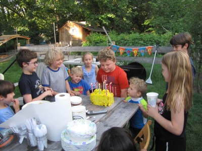 Harvey blowing out his candles amongst a delighted throng