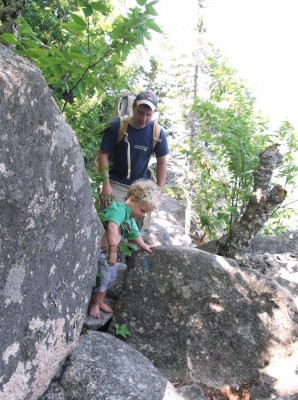 Harvey hiking among boulders with Dada following