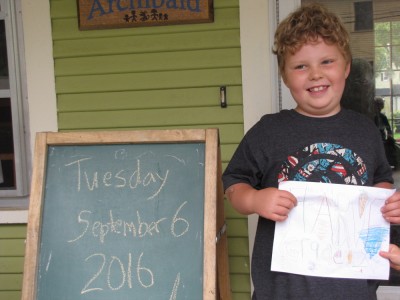 Harvey smiling holding his second grade sign