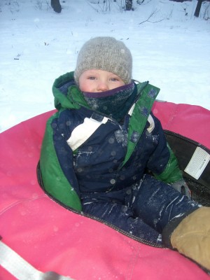 Harvey on the sled, bundled up against the cold