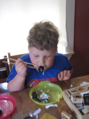 Harvey eating homemade sushi with chopsticks