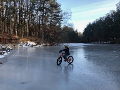 Elijah riding his bike on the ice at the reservoir