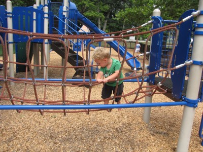 Lijah crossing a rope bridge thing on the playground