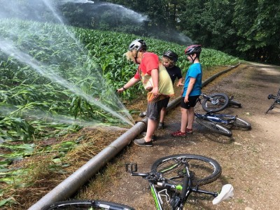 Harvey, Zion, and a friend checking out the big spray from a leak in an irrigation line