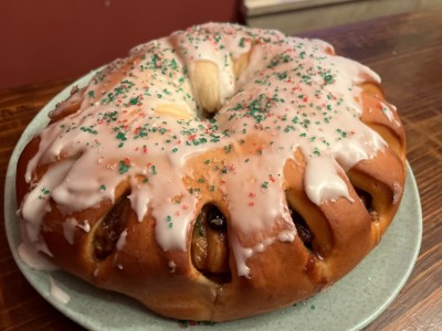 a yeast cake with glaze and sprinkle sugar on a plate