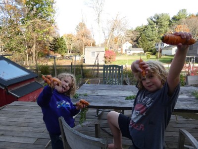 Zion and Elijah holding carrots on our back deck