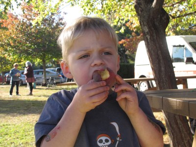 Zion eating a late-october peach at the farmers market