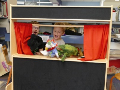 Lijah and Jack doing a puppet show at the library