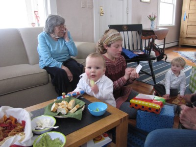 Elijah standing at the coffee table amidst food and presents