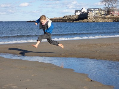 Elijah jumping over a stream on the beach