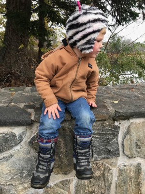 Lijah in cold-weather gear sitting up on a wall