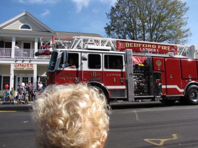 the back of Lijah's head as he watches the ladder truck go by