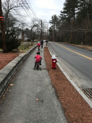 Lijah on his training wheel bike following his brothers