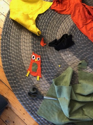 pieces of a felt owl assembled on the rug