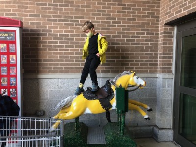 Elijah standing on the horse ride at Market Basket