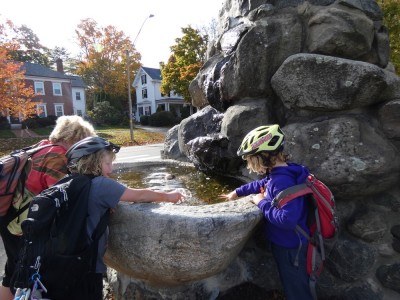 the boys splashing water in the wishing pool at the Lexington Minuteman statue