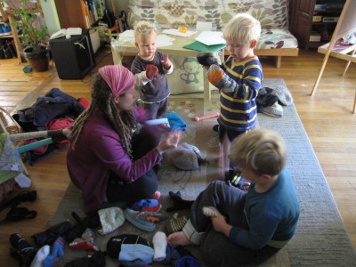Mama and the boys in the playroom sorting winter gear