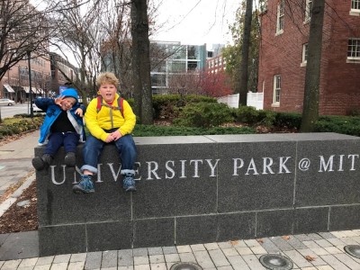 Harvey and Zion sitting on a stone wall sign at MIT